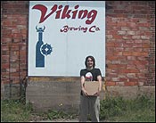 Me outside by the Viking Brewery sign with my case of beer that I bought. 